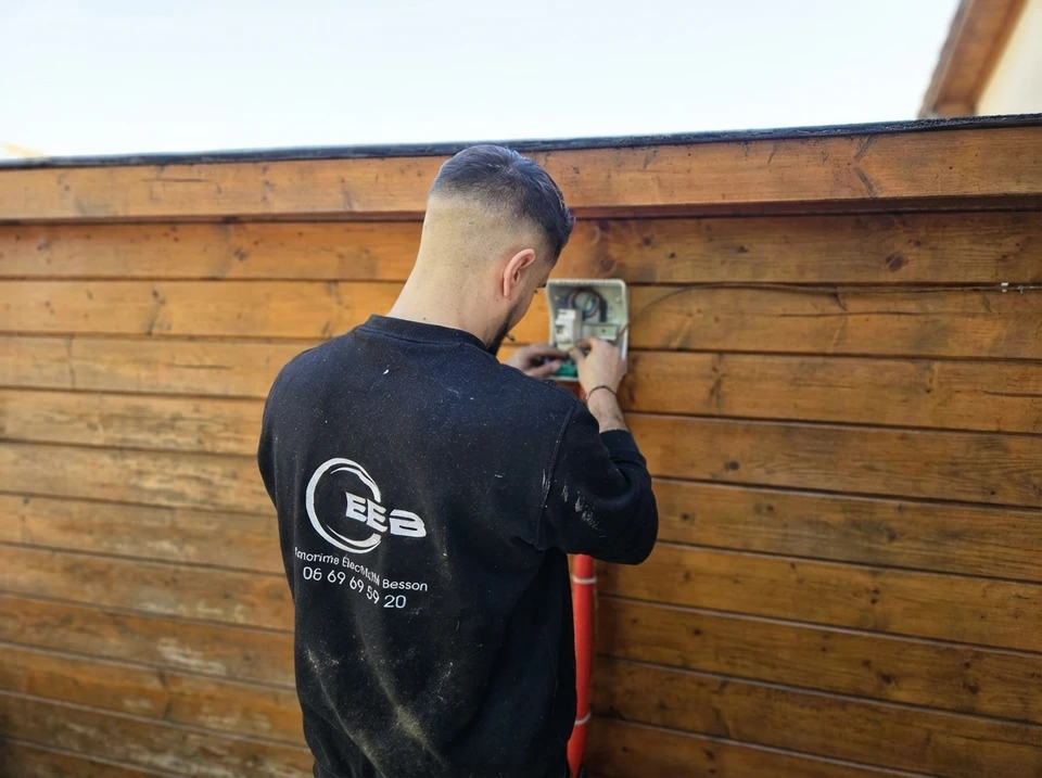 Électricien installant des prises murales dans un intérieur résidentiel