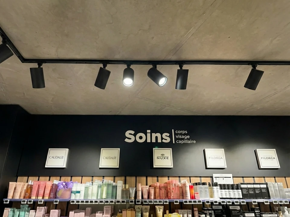 Un électricien installe des projecteurs au plafond
