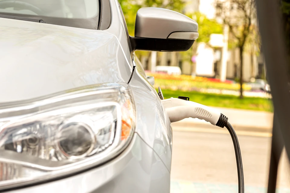 Extérieur urbain, véhicule électrique blanc en charge