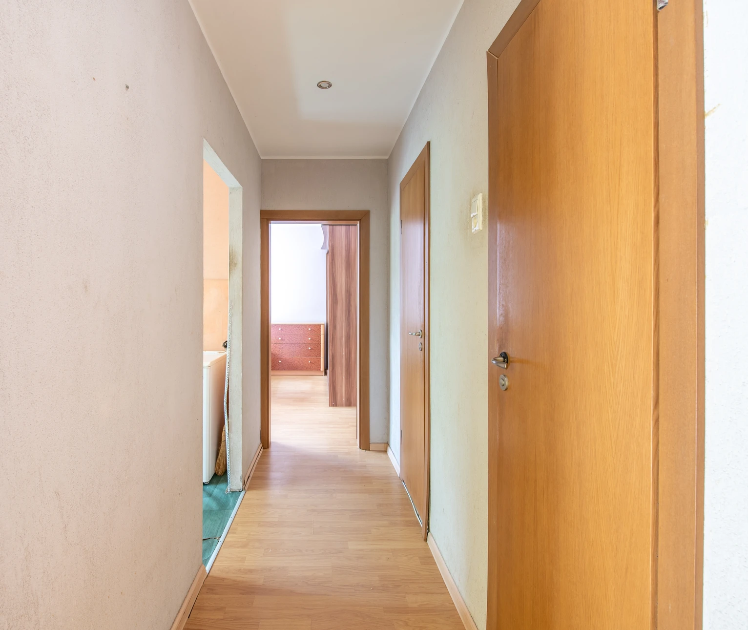 Intérieur en cours de rénovation avec mur partiellement enduit, installation électrique apparente avec conduits et boîtiers orange